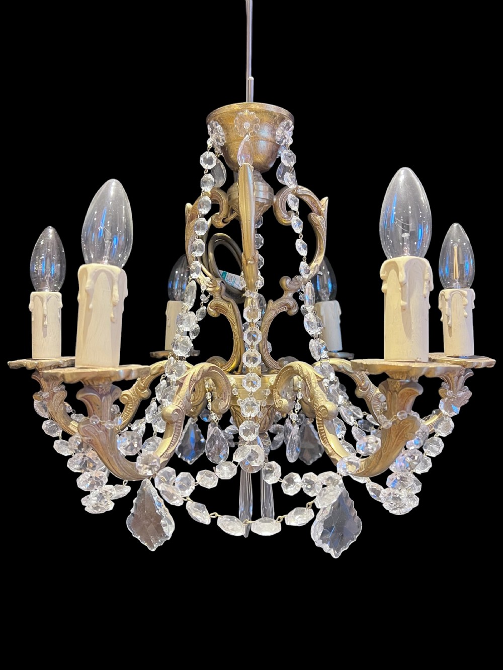 a pair of six light french brass and crystal chandeliers